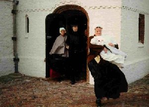 Twee Katwijkse vroue loop uit die wit Hervormde Kerk uit