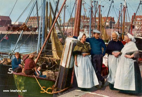 Vissers en hul pragtig aangetrekte vroue laat hulle afneem op die hawe van die voormalige dorp 
Scheveningen, wat nou sy 
karakter gaan verloor weens die stadskultuur van die groter stad Den Haag